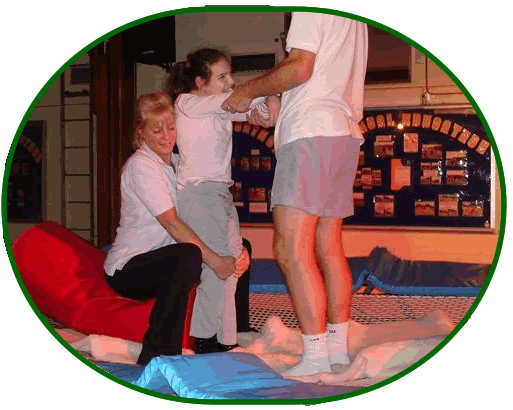 picure showing staff and a student on a  trampoline using specialist equipment